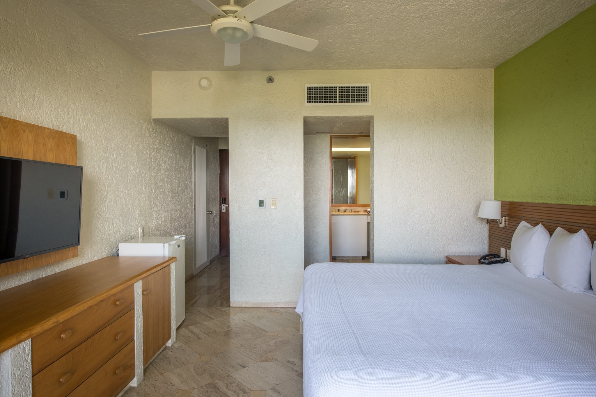 Spacious room with King bed and view into bathroom at Park Royal: Club Regina Cancun.