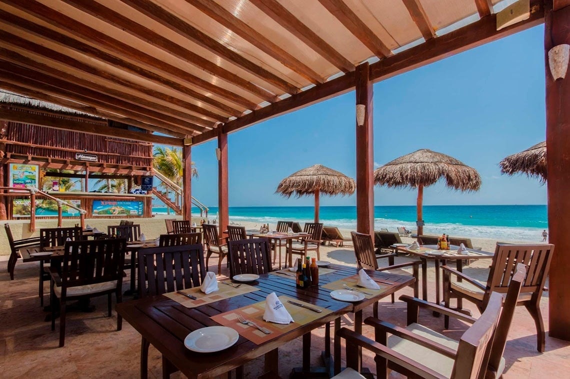 Restaurante de Park Royal: Club Regina Cancún frente al mar con mesas listas.