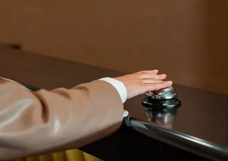 Mano presionando el timbre de recepción en Park Royal: Club Regina Cancún.