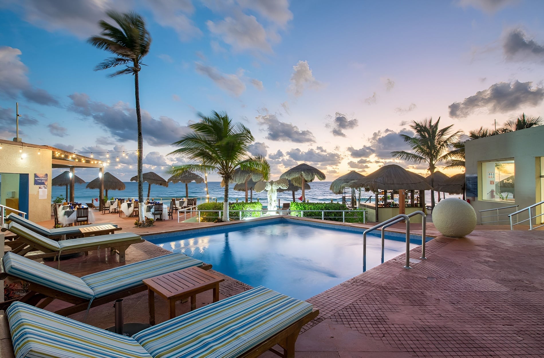 Piscina y playa en Park Royal: Club Regina Cancun al atardecer.