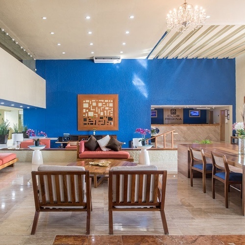 Lobby de Park Royal: Club Regina Cancún. Sofás, mesa de madera y decoración vibrante.