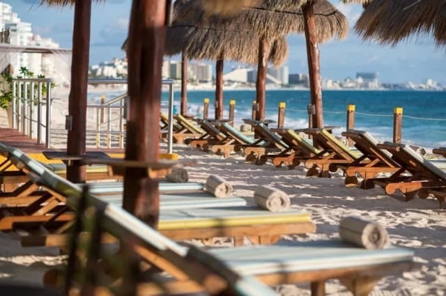 Tumbonas bajo sombrillas en la playa de Park Royal: Club Regina Cancun.