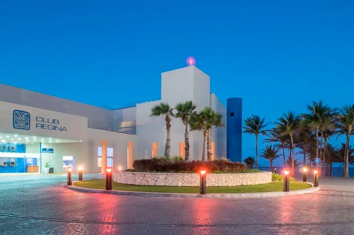 Entrada del Park Royal: Club Regina Cancun con palmeras y luces.