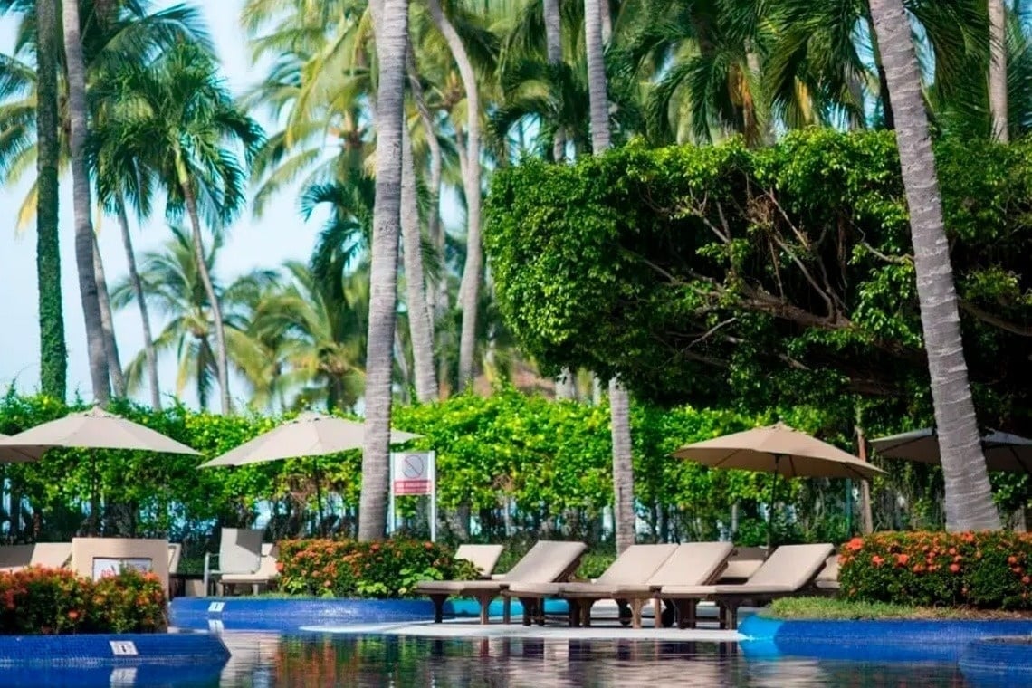 Tumbonas junto a la piscina en Park Royal: Club Regina Puerto Vallarta.