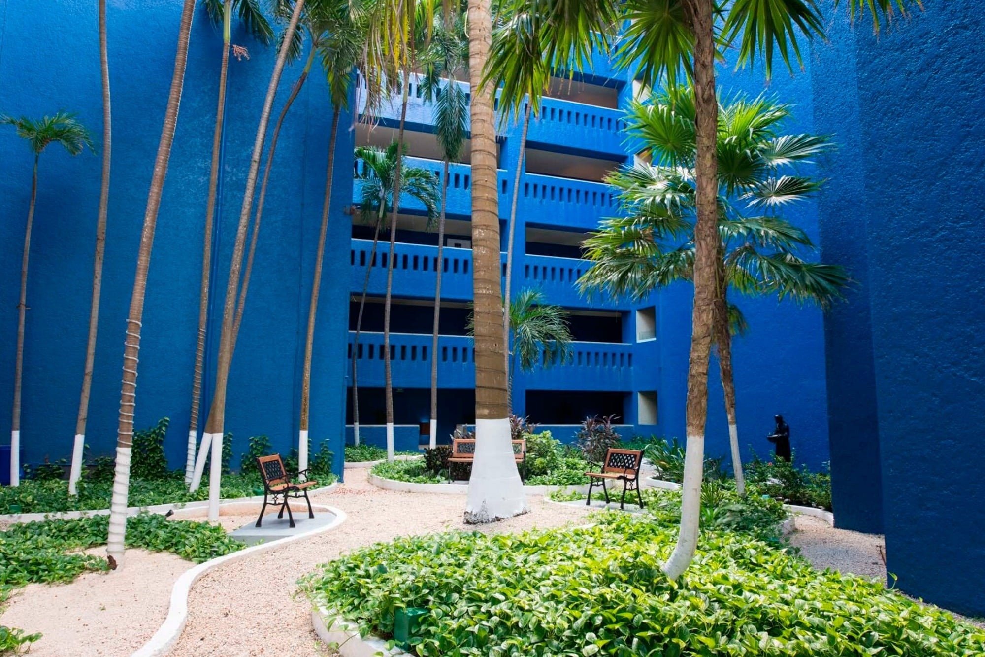 Jardines tropicales y arquitectura azul vibrante en Park Royal: Club Regina Puerto Vallarta.