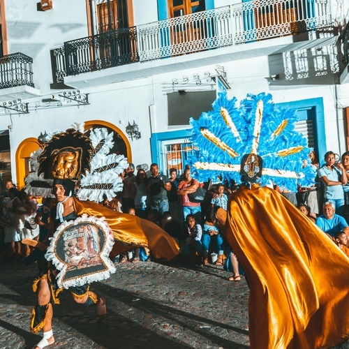 Desfile cultural frente al Park Royal: Club Regina Puerto Vallarta, con danzantes y público.