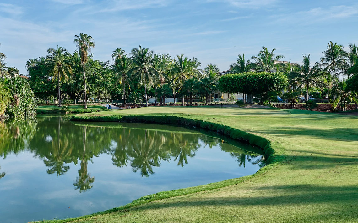 Campo de golf en Park Royal: Club Regina Puerto Vallarta con lago y palmeras.