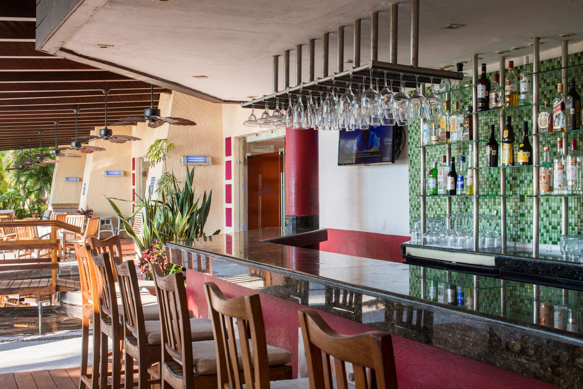 Bartender sonriente en Park Royal: Club Regina Puerto Vallarta, preparando cócteles.