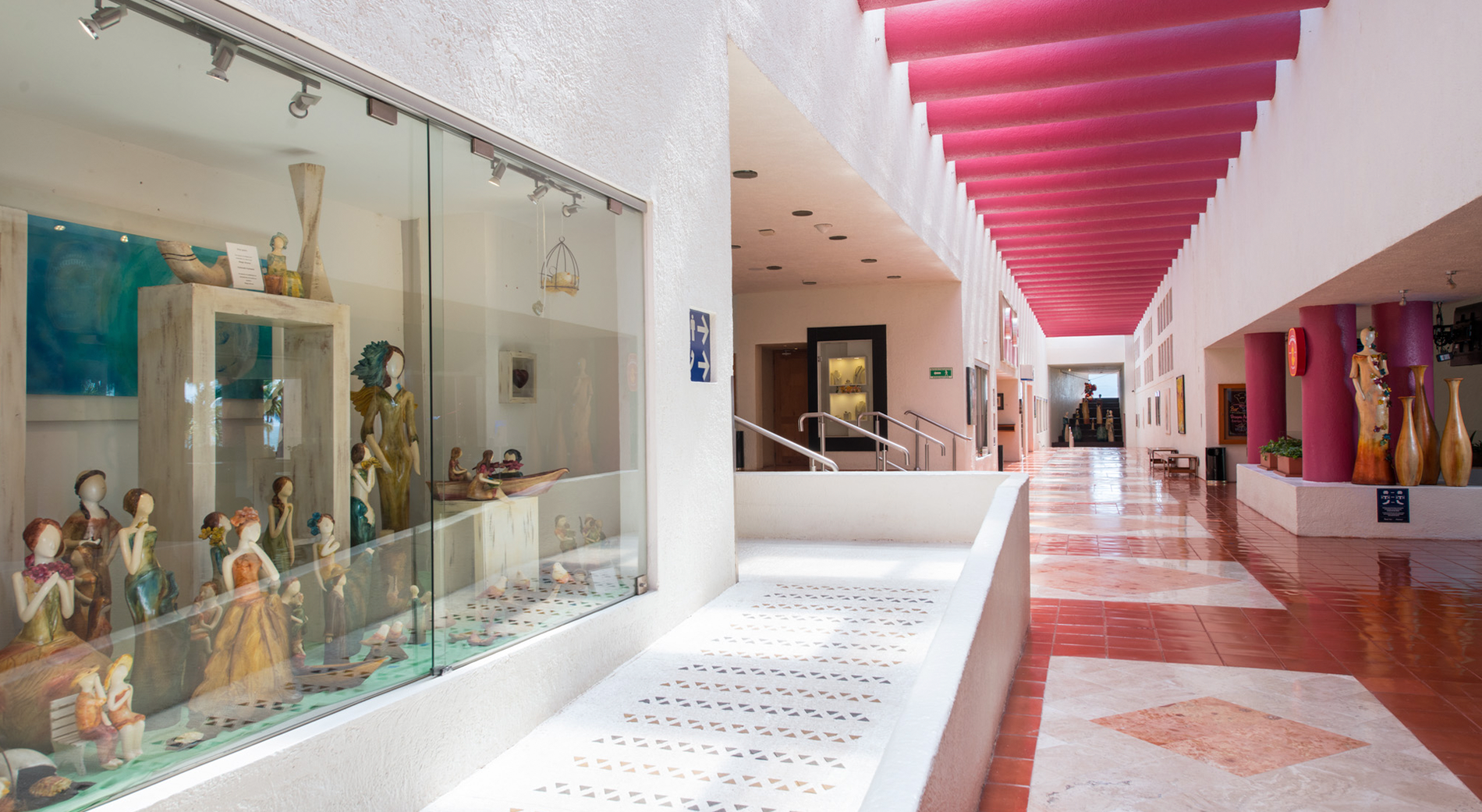 Pasillo del hotel Park Royal: Club Regina Puerto Vallarta con exhibición de arte y arquitectura vibrante.