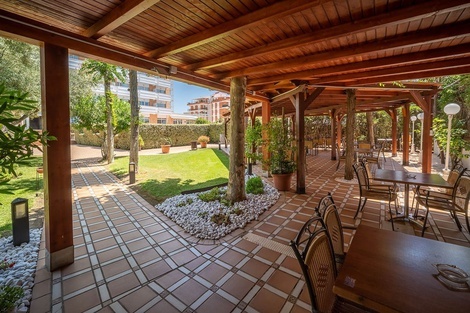 un patio con mesas y sillas y un techo de madera