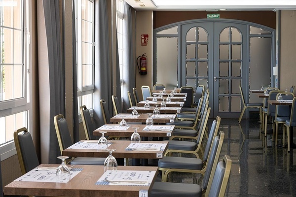 Pato: Corporativa hotel dining room with prepared tables, ideal for corporate events or guest meals.