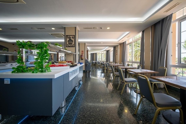 Bright Pato Corporativa hotel buffet restaurant: modern dining area with food stations, tables, and scenic window views.