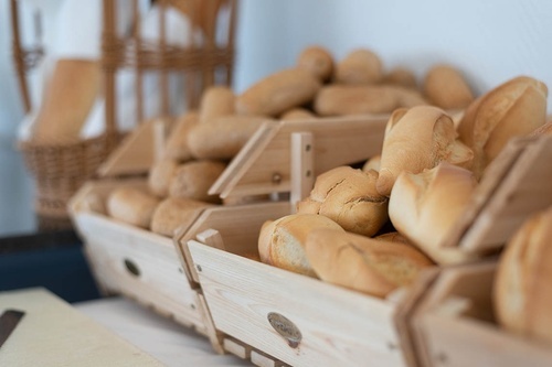 Fresh bread rolls and baguettes in wooden displays for breakfast at Pato Rojo Hotel, Punta Umbria.
