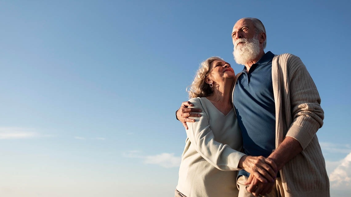 Pareja mayor feliz bajo el sol, reflejo de los valores Pato: Corporativa.