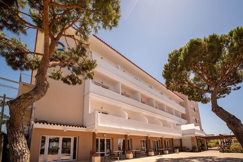 Pato Rojo Hotel, Punta Umbria (Huelva): multi-story hotel exterior with balconies, pine trees, and patio.