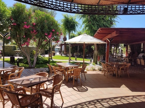 Hotel Pato Amarillo 4-star outdoor restaurant terrace, Punta Umbría, Huelva, amidst lush gardens.