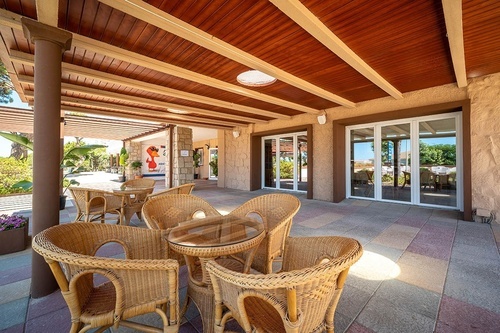 Sunny outdoor lounge area with wicker seating at Pato Rojo Hotel in Punta Umbria, Huelva.