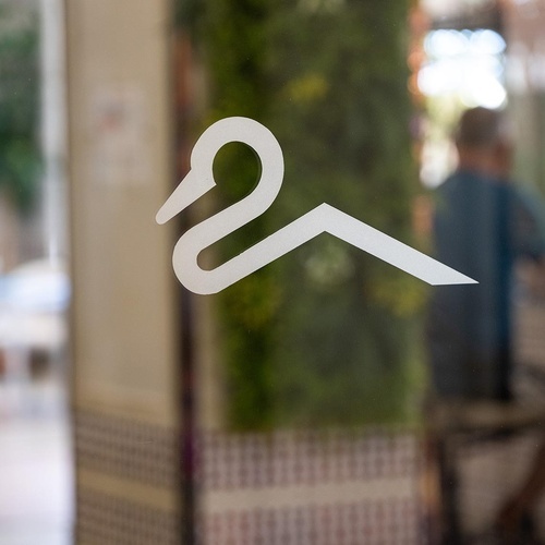 Swan and roof logo on glass at Hotel Pato Amarillo, a 4-star hotel in Punta Umbría.