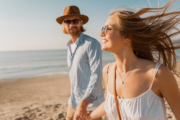 Pareja feliz en playa soleada, perfecta para tu evento Pato: Corporativa.