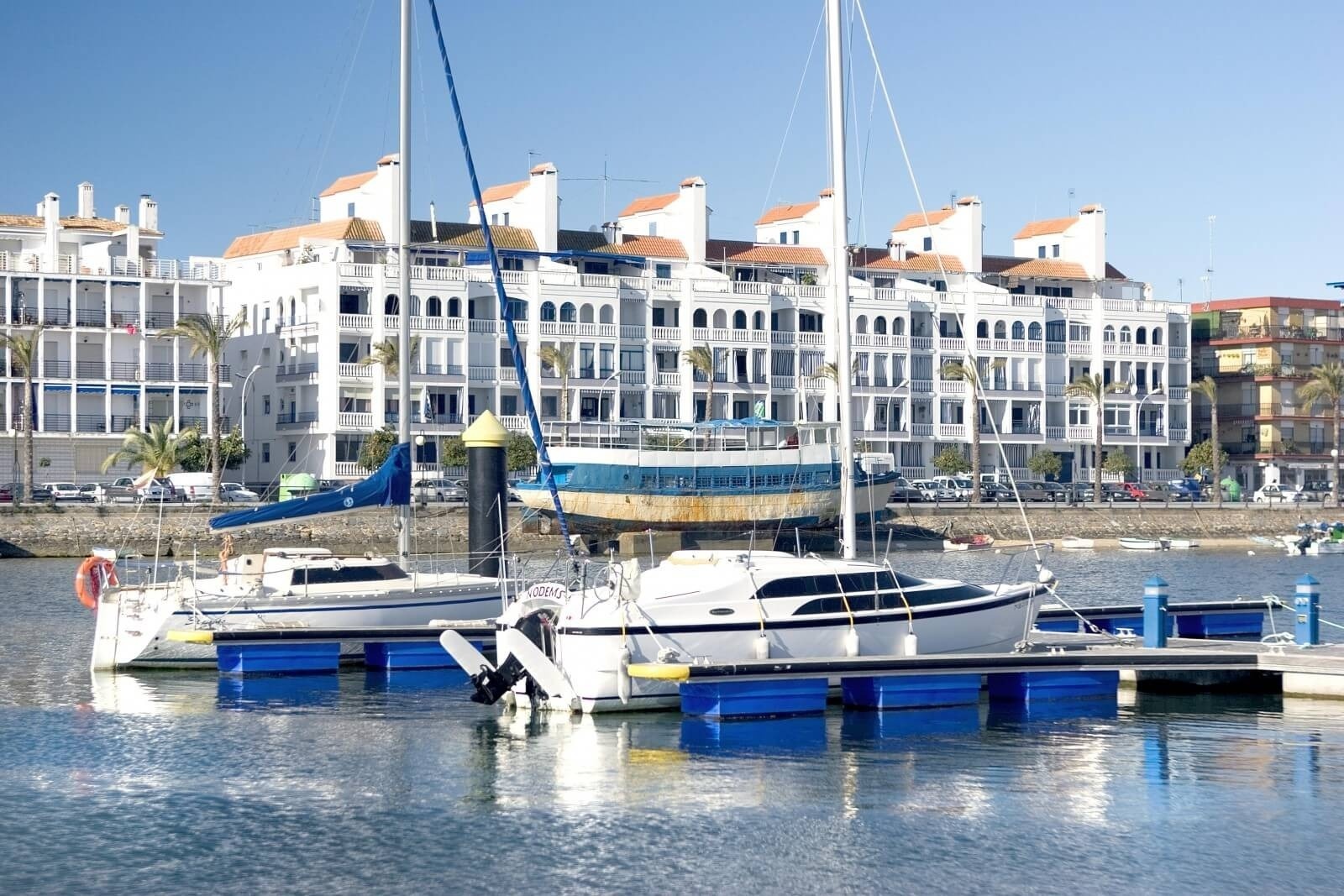 Vista da marina com hotéis brancos e iates, ideal para Pato: Corporativa.