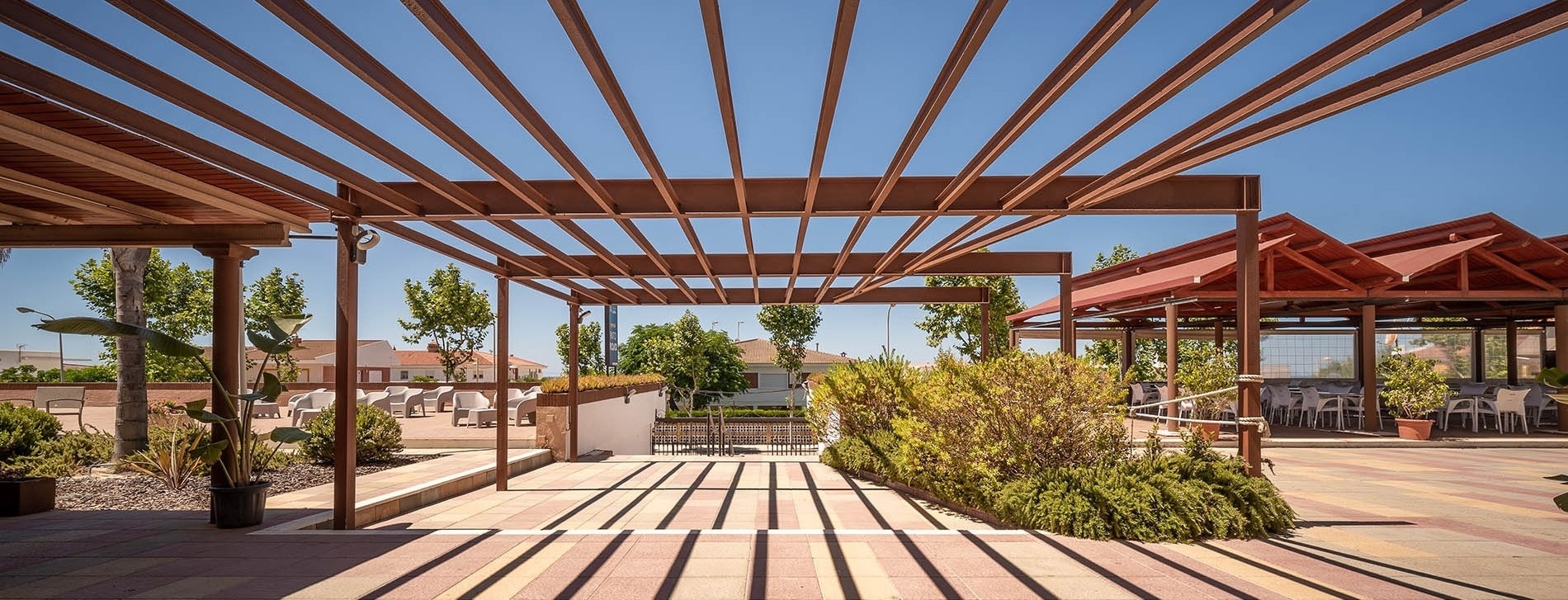 Pato Hotels Punta Umbría (Huelva) gallery: Sunny outdoor patio with modern pergolas, lush plants, and comfortable seating.