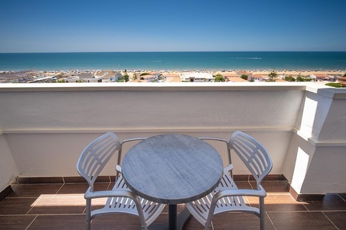 Balcony with sea view from Hotel Pato Amarillo, 4-star hotel in Punta Umbría (Huelva), featuring a table and chairs.