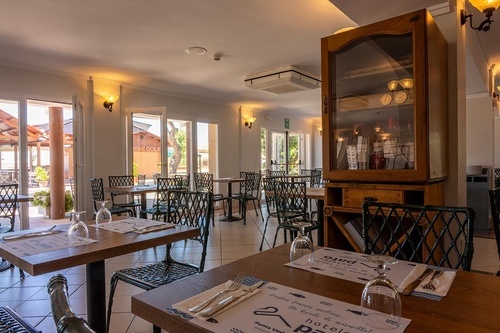 Inviting Pato Rojo Hotel restaurant, Punta Umbria. Set tables, natural light, and outdoor terrace with mini golf.