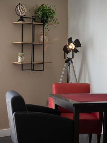 Stylish Pato Rojo Hotel interior, Punta Umbria. Modern decor, shelving, plant, unique lamp & seating.