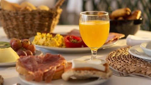 Pato Rojo Hotel | Hotel in Punta Umbria: Fresh breakfast spread with juice, ham, eggs & fruit.