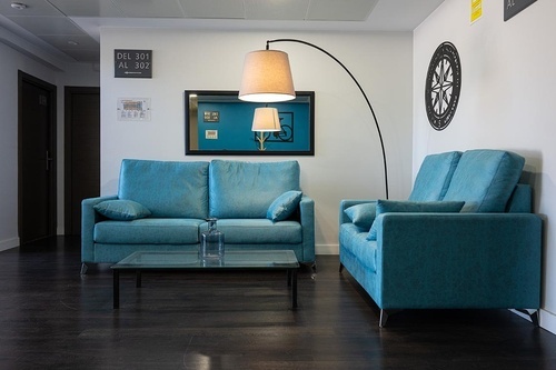 Pato Rojo Hotel, Punta Umbria: Relaxing lobby with teal sofas, modern arc lamp, and elegant decor.