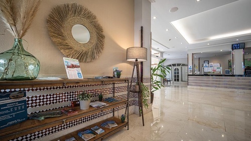 Inviting lobby at Hotel Pato Amarillo, a 4-star hotel in Punta Umbría, Huelva, featuring stylish decor and reception desk.