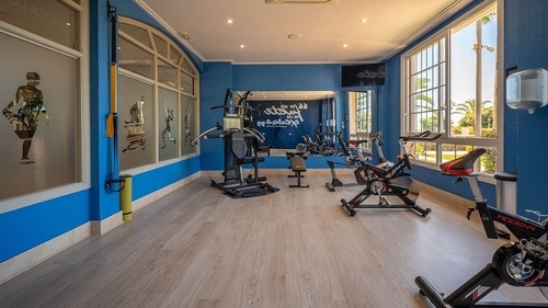 Hotel Pato Amarillo gym with exercise bikes, multi-gym, bright windows. 4-star hotel in Punta Umbría.