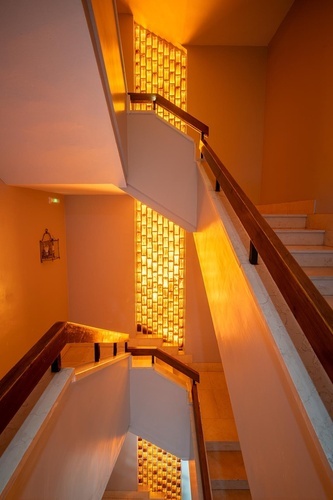Warm, glowing staircase with golden glass wall at Hotel Pato Amarillo | 4-star hotel in Punta Umbría, Huelva.