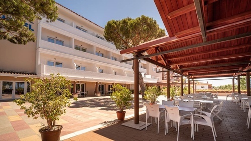 Pato Rojo Hotel in Punta Umbria, Huelva: Sunny hotel exterior with patio and outdoor dining area.