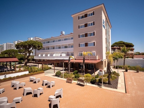 Pato Rojo Hotel in Punta Umbria, Huelva: Sunny exterior with patio, seating, and vibrant greenery.