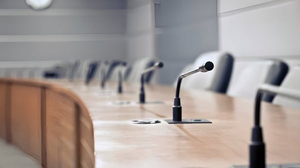 una sala de conferencias con micrófonos y sillas