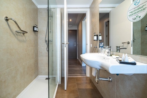 Stylish Pato Rojo Hotel bathroom in Punta Umbria with walk-in shower, floating vanity, and neutral tiles.