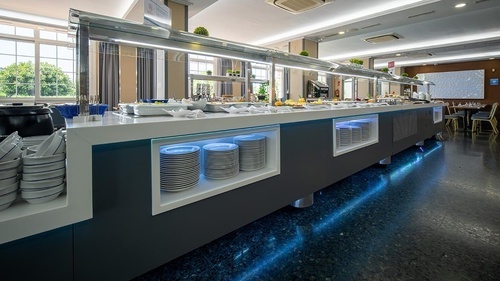 Modern buffet with fresh food and blue lighting at Hotel Pato Amarillo, 4-star hotel in Punta Umbría (Huelva).