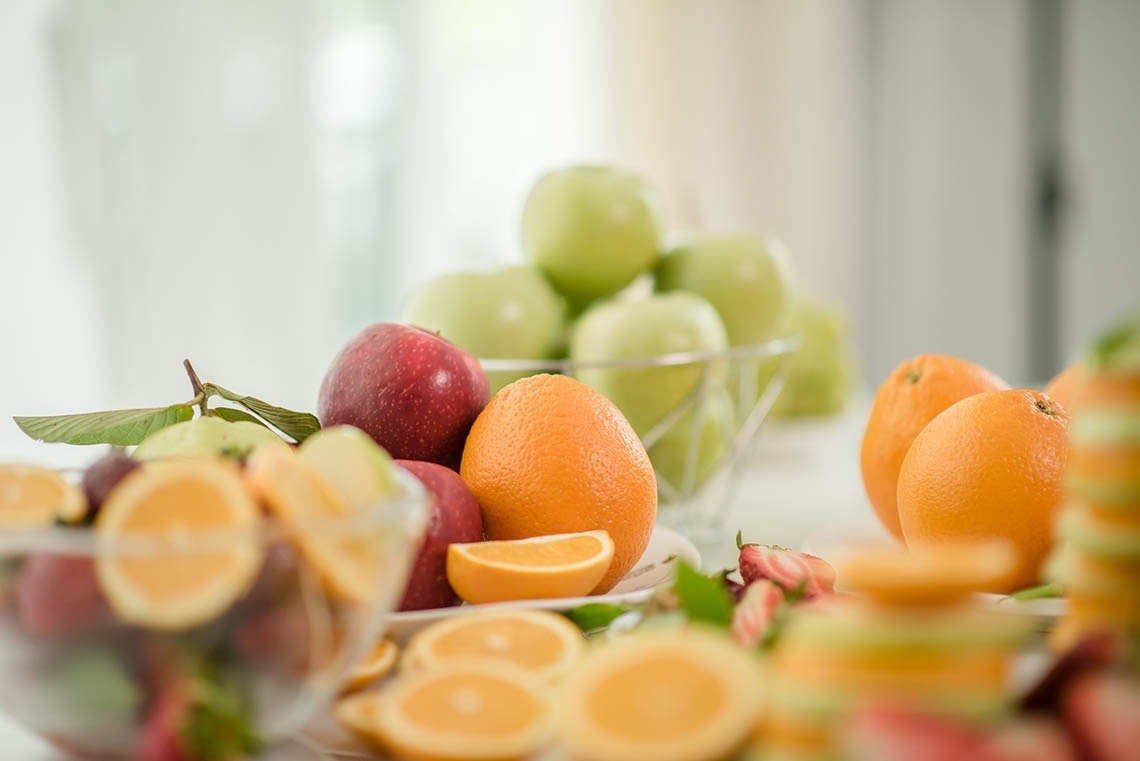 Pato: Corporativa's vibrant fresh fruit display: apples, oranges. Healthy hotel choice.