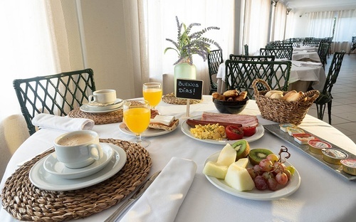Abundant breakfast at Pato Rojo Hotel in Punta Umbria with hot dishes, fresh fruit, and coffee.