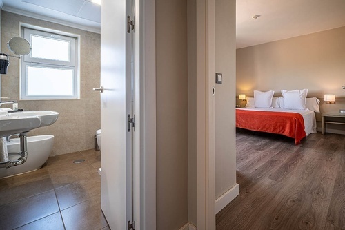 Pato Rojo Hotel in Punta Umbria: comfortable guest room with a cozy bed, modern bathroom, and hardwood floors.
