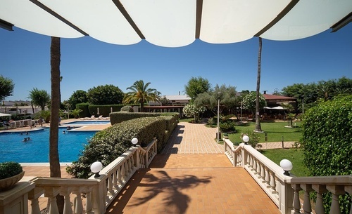 Hotel Pato Amarillo: Inviting outdoor pool and tranquil gardens under a bright sky in Punta Umbría.