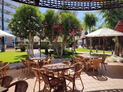 Hotel Pato Amarillo, 4-star outdoor terrace with lush gardens and seating in Punta Umbría, Huelva.