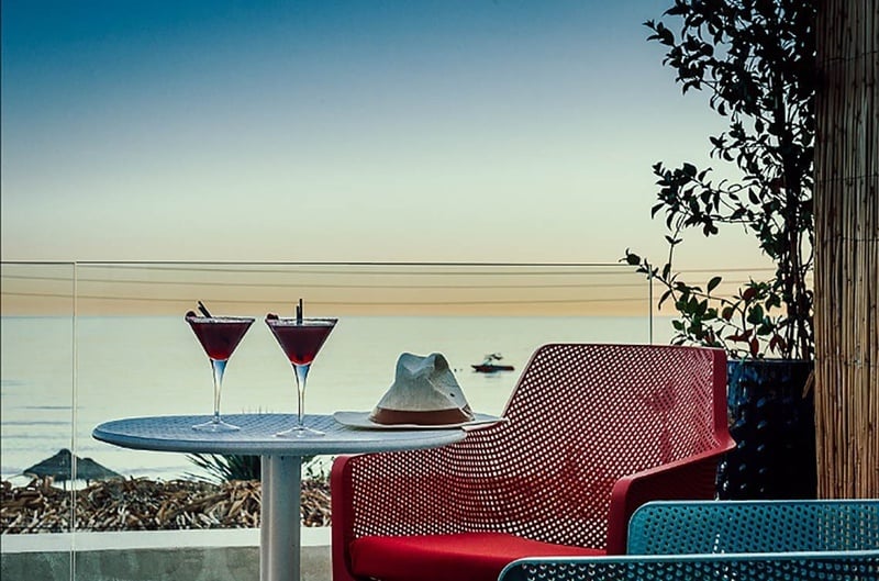 dos cócteles están sobre una mesa junto a una silla roja