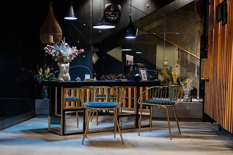 Recepción del H. Boutique Peña Parda, con mostrador de diseño, lámparas colgantes y butacas doradas.