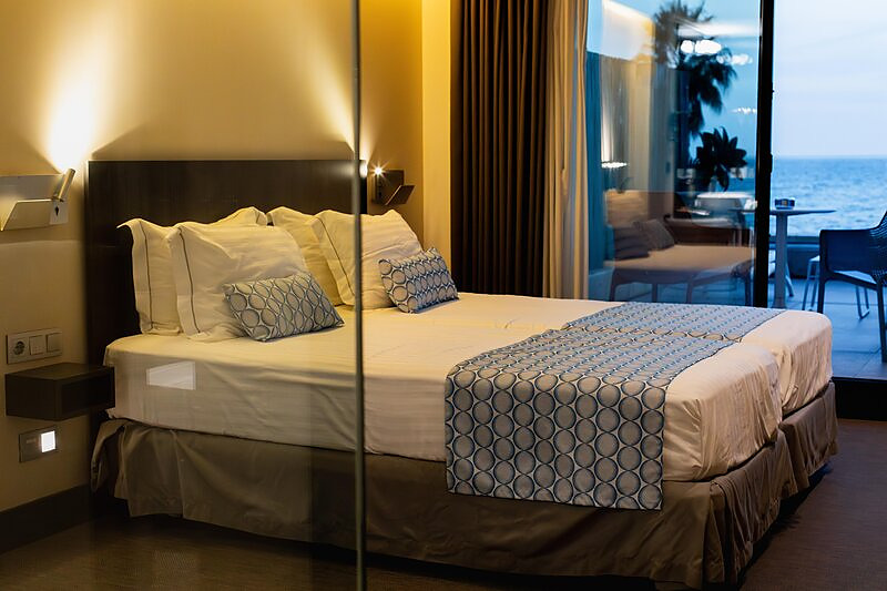 Habitación del H. Boutique Peña Parda con la cama preparada y balcón con vistas al mar.