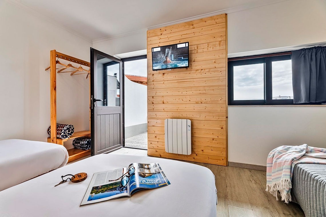 uma cama com colchão branco e cabeceira de madeira