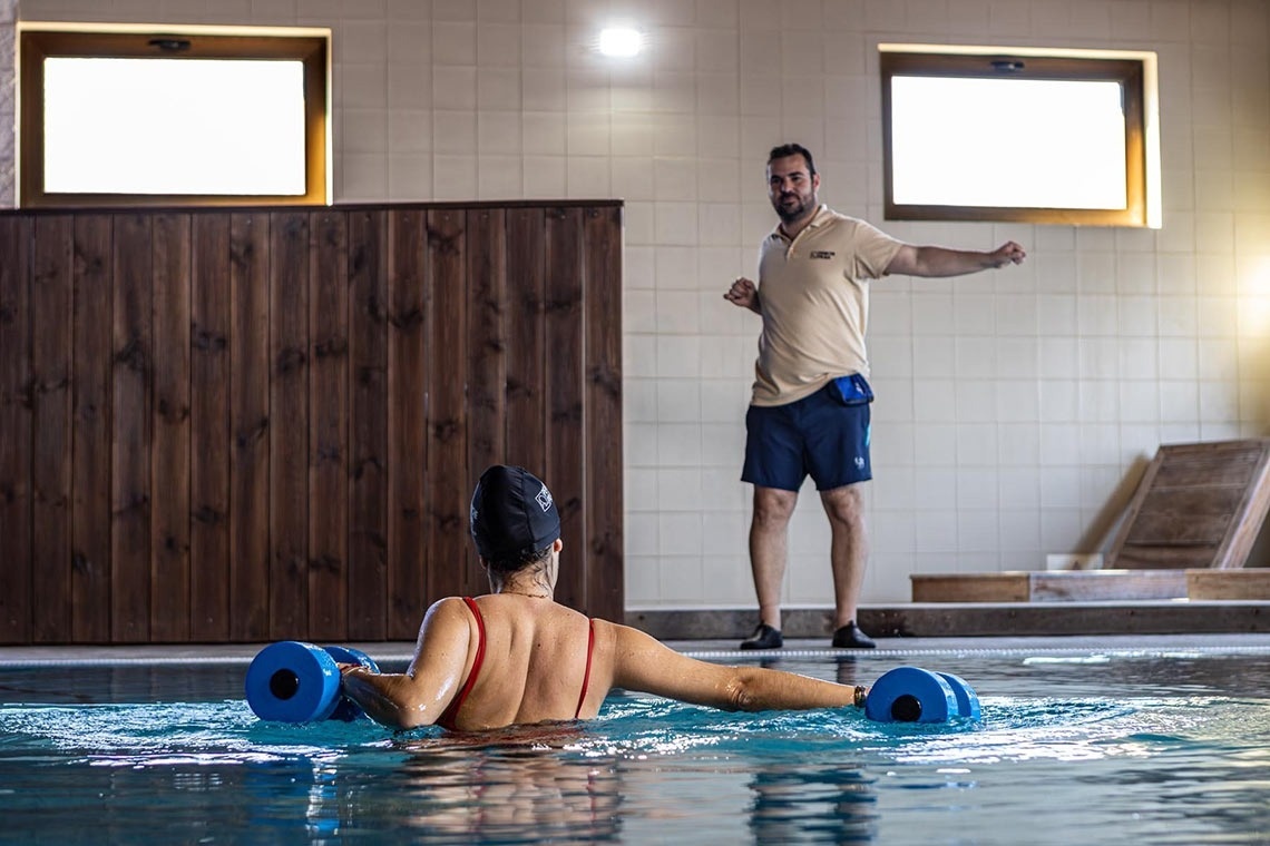 a man standing next to a woman in a swimming pool wearing a shirt that says lg