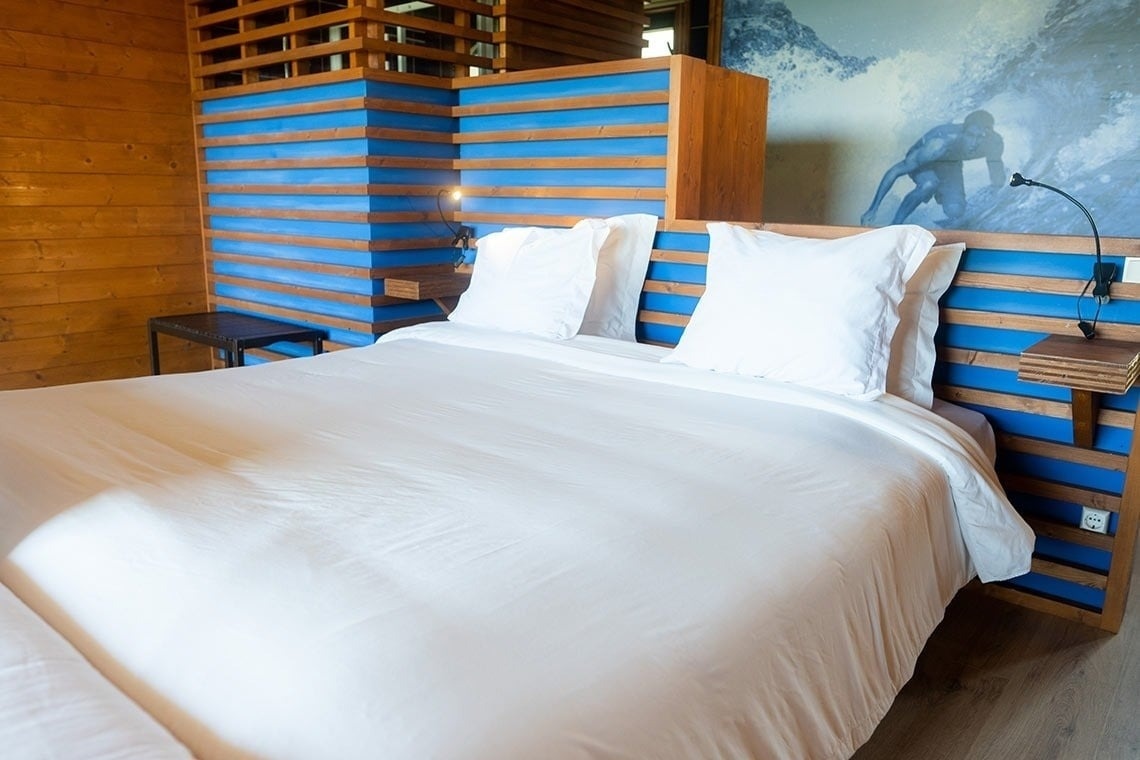 Lit douillet à PenichePraia, design moderne en bois et bleu.