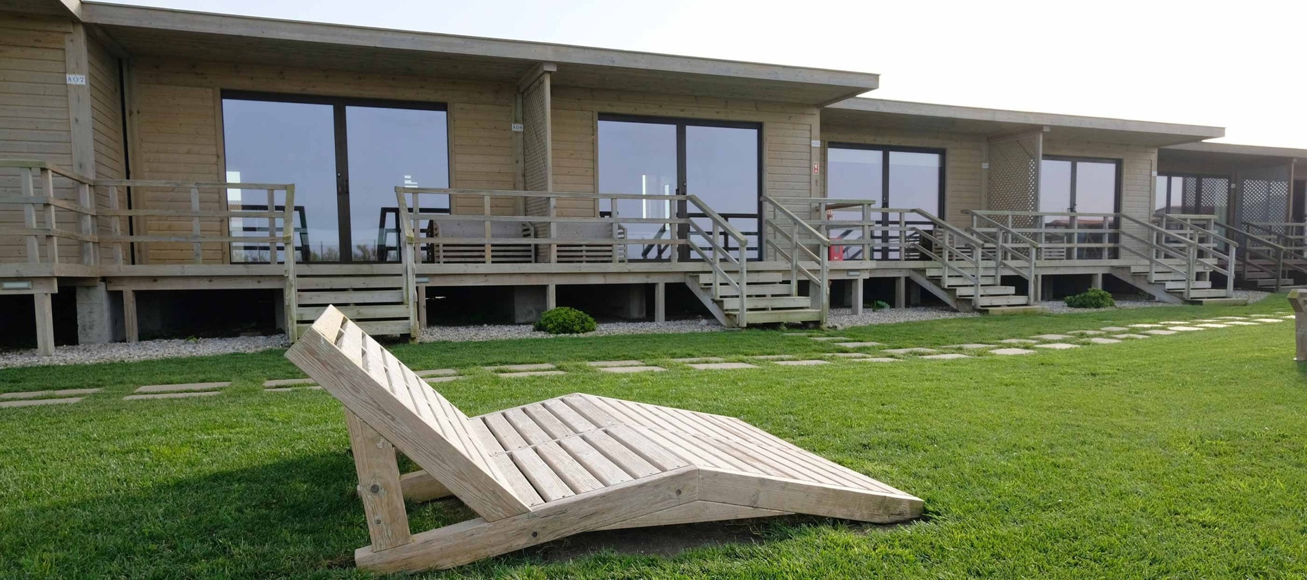 a wooden chair sits in front of a row of houses